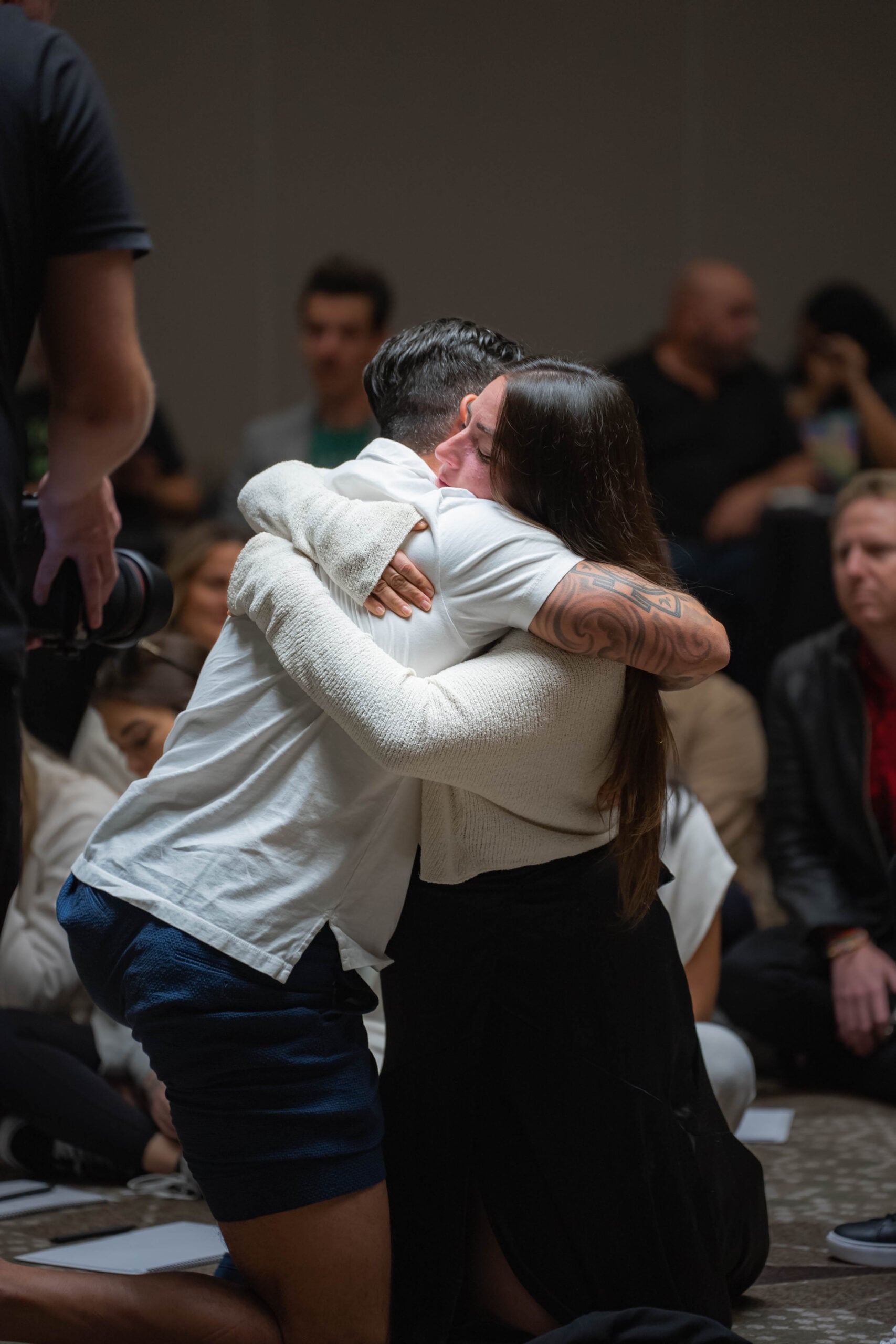 Two guests in a long, tearful embrace