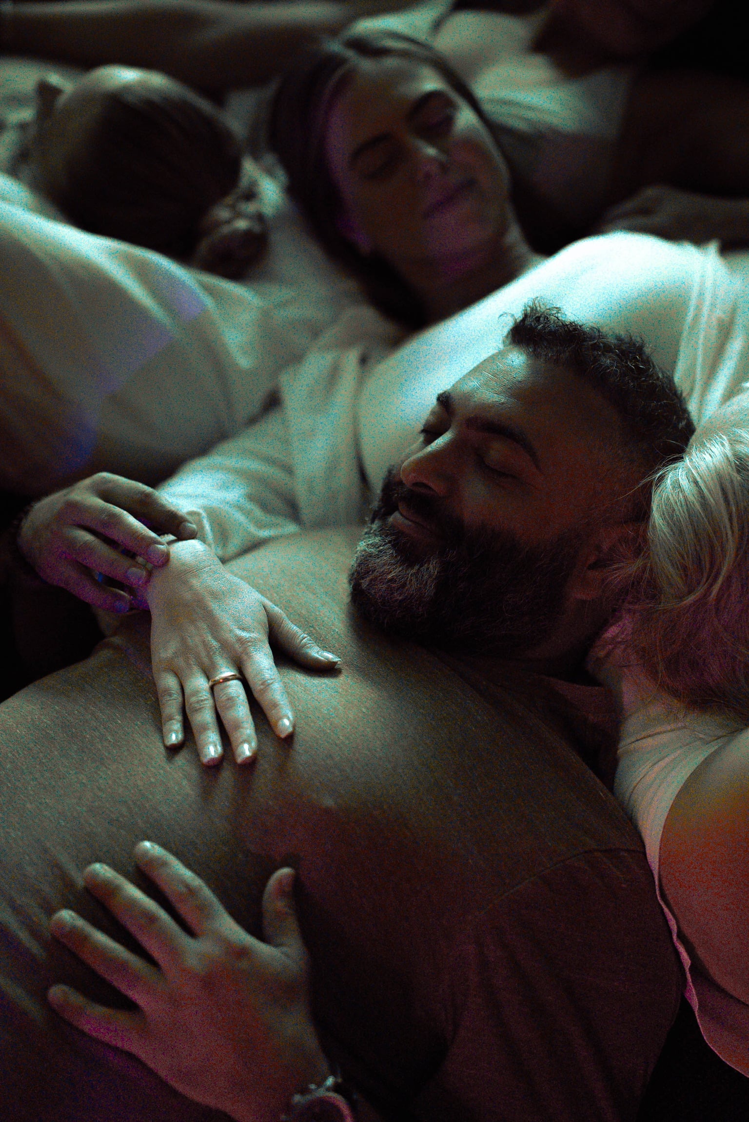 Guests resting together, eyes closed, hands on one another